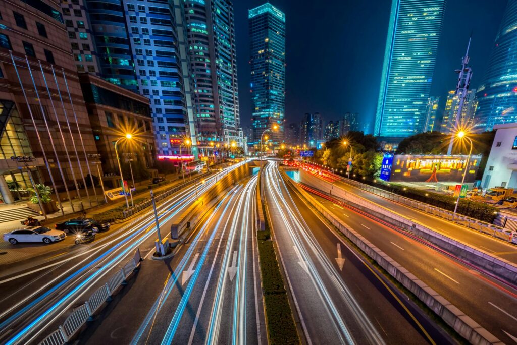 web traffic Dynamic long exposure night shot of urban cityscape with vibrant light trails and towering skyscrapers.