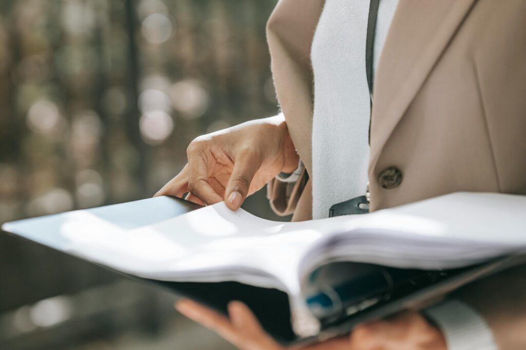 pexels-photo-5999874-5999874 Crop faceless female entrepreneur in stylish jacket reading important documents in black folder